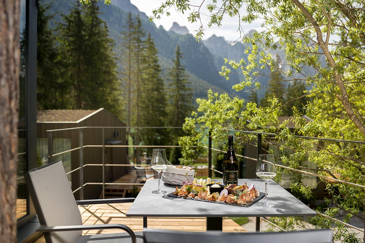 Table with delicacies outdoors in summer • SkyView Chalets Toblacher See