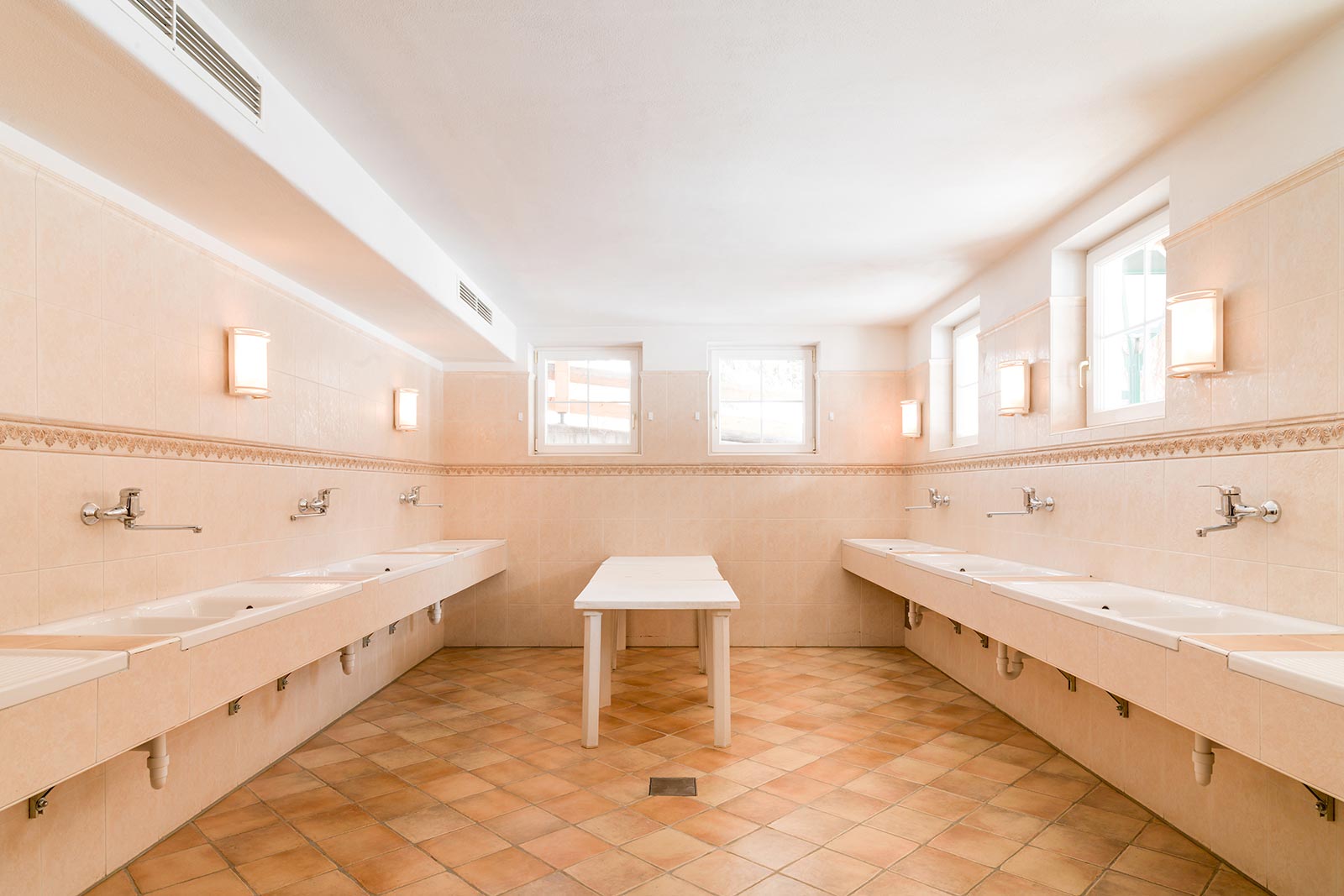 Innenaufnahme - Gemeinschaftsbadezimmer mit Waschbecken & Tisch - Camping Toblacher See